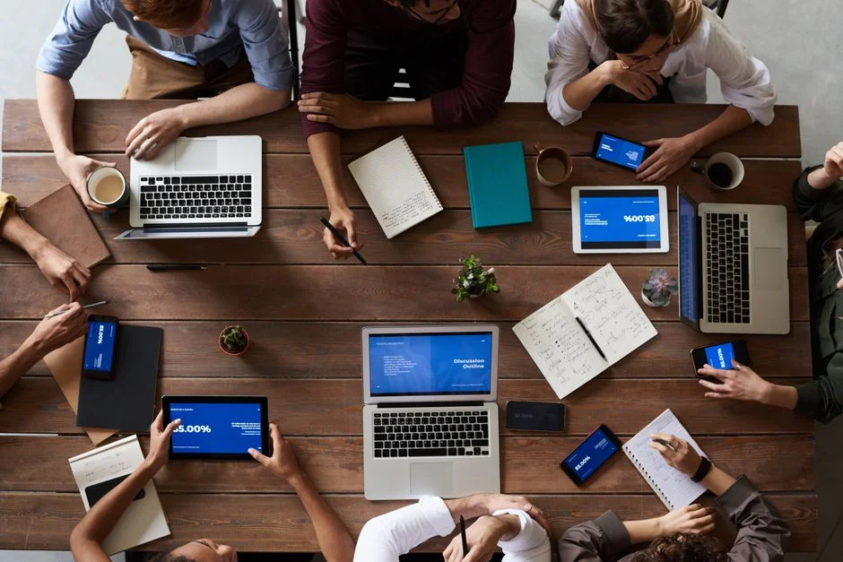 Une équipe examine des graphiques financiers et des données numériques sur des tablettes dans un environnement de bureau.